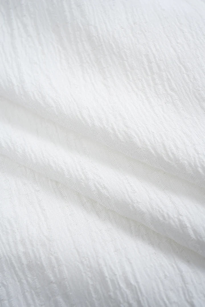 Camisa CASANDRA asimétrica de manga larga sin espalda con botones.