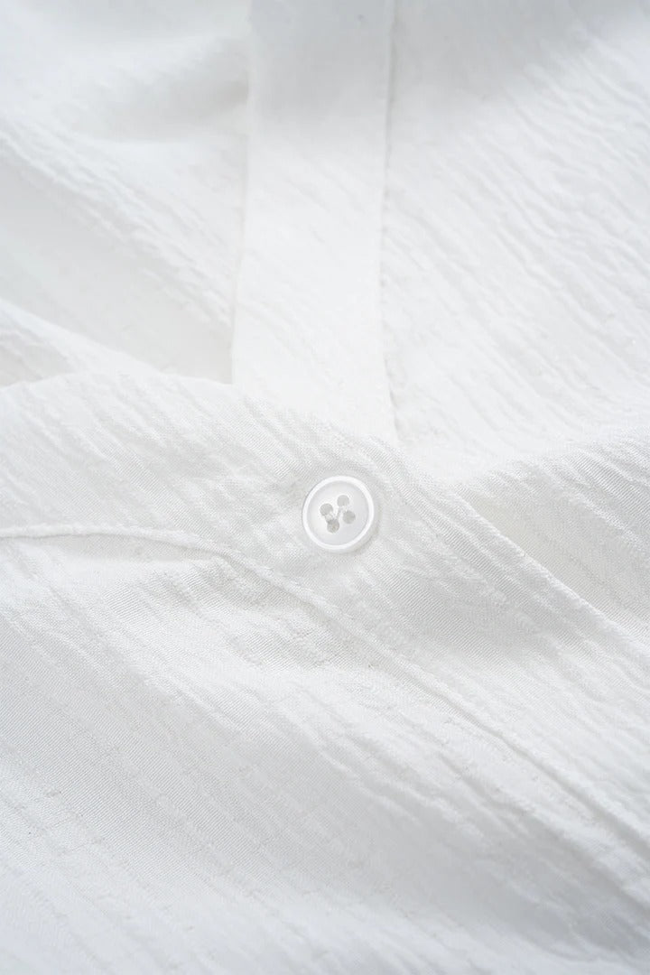 Camisa CASANDRA asimétrica de manga larga sin espalda con botones.