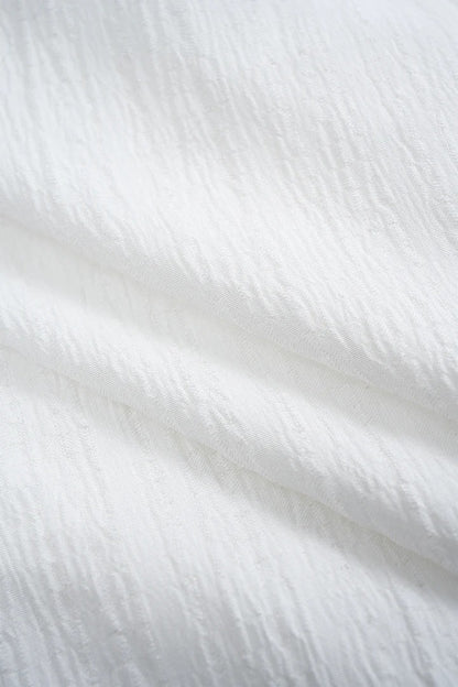 Camisa CASANDRA asimétrica de manga larga sin espalda con botones.