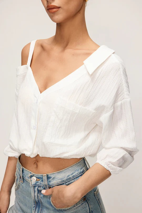 Camisa CASANDRA asimétrica de manga larga sin espalda con botones.